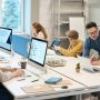 Professional business team collaborating in modern office with computers and technology